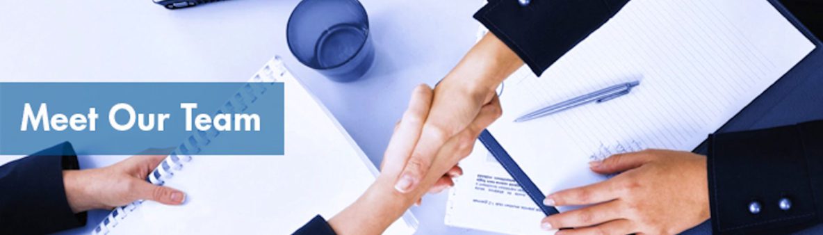 Two people shaking hands over a document and a glass of water.
